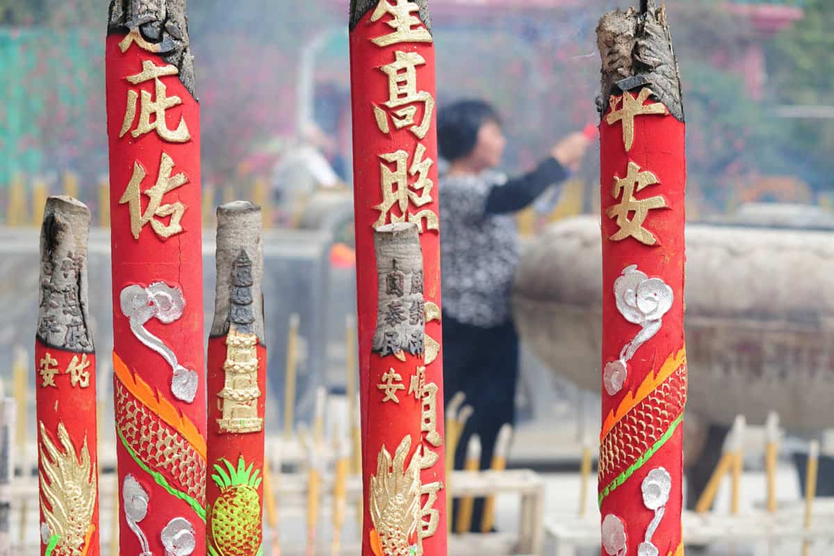 Red engraved incense burning outside the temple