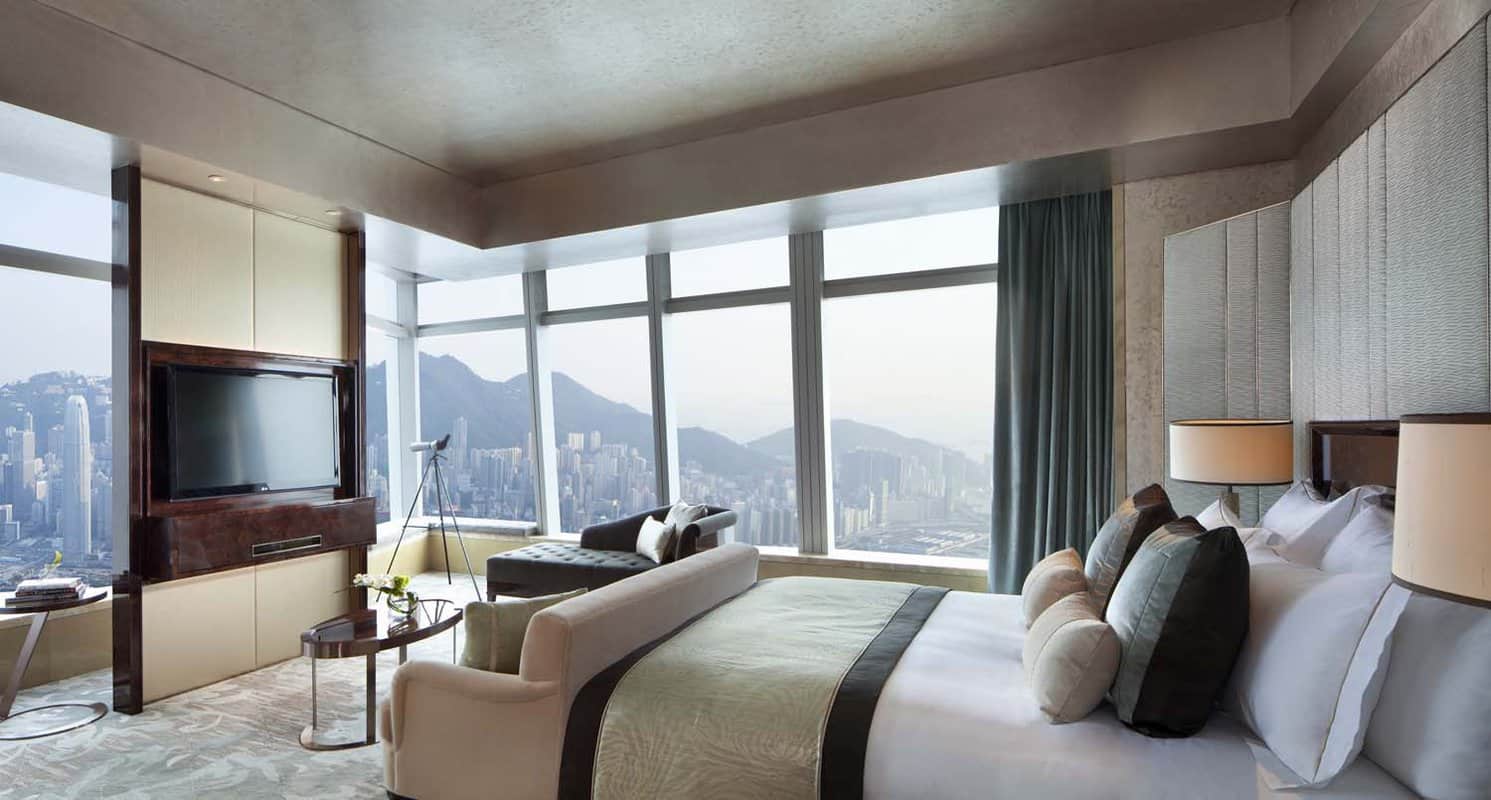 Large double bed and living area with a TV and a view over the peak