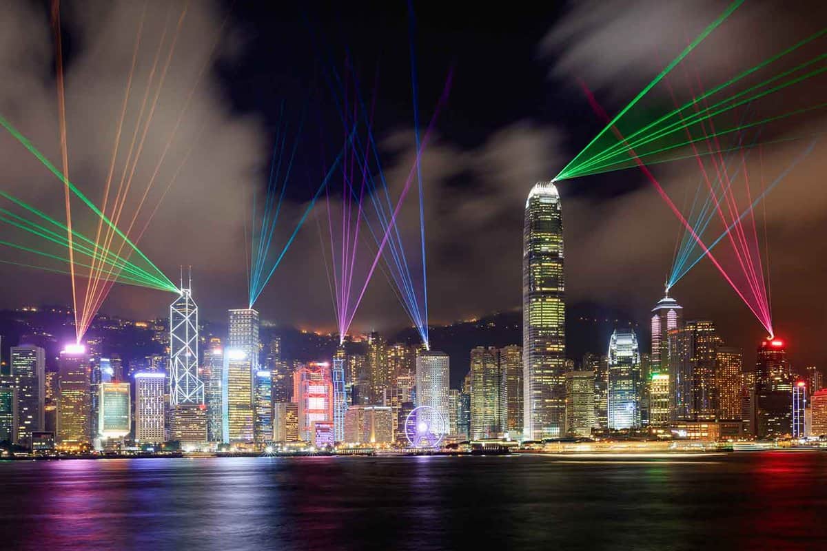 Laser show from tall skyscrapers along the harbour at night time