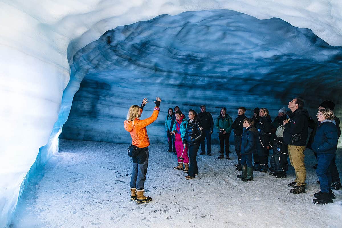 Tour guide showing tour group in a ice cave