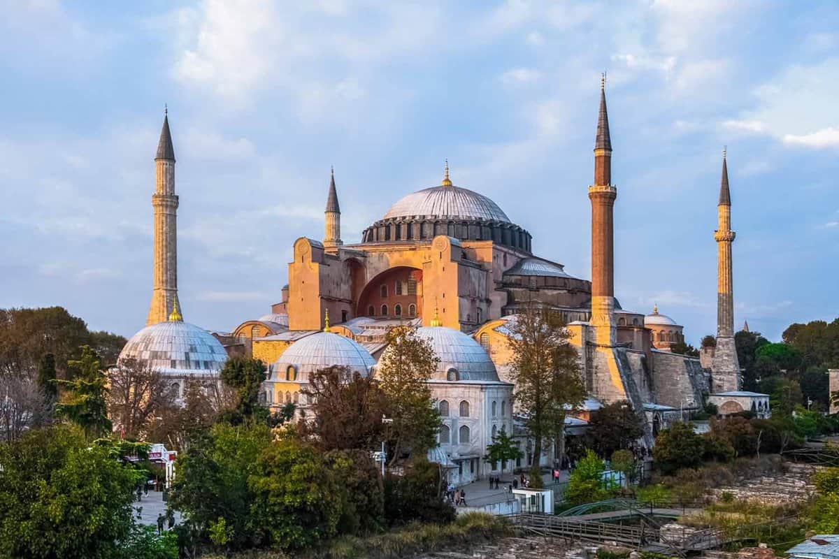 Exterior of grand mosque with four minarets at golden hour