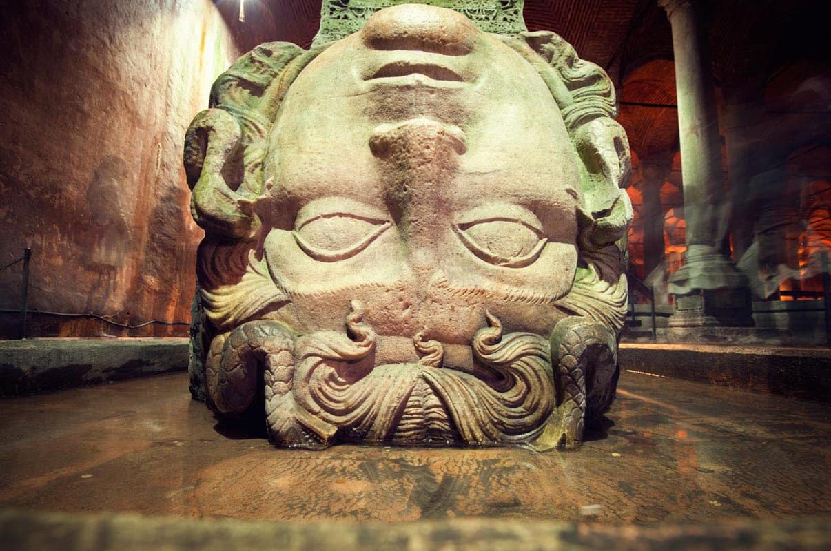 Upside down stone head of Medusa resting on the ground