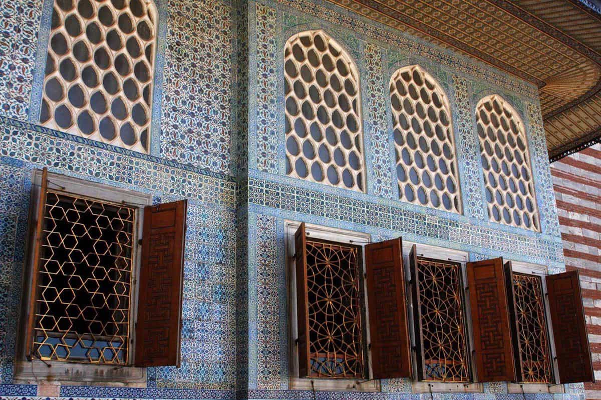 Wooden palace windows on a blue-tiled wall