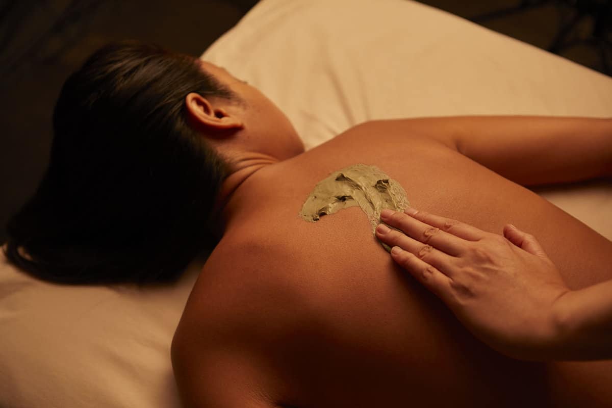 Woman receives mud massage in spa