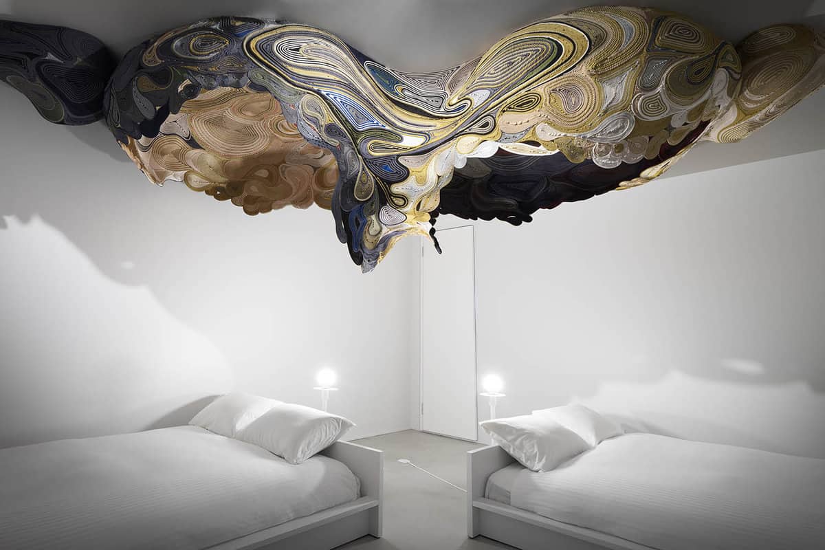 Beds under metal ceiling art installation