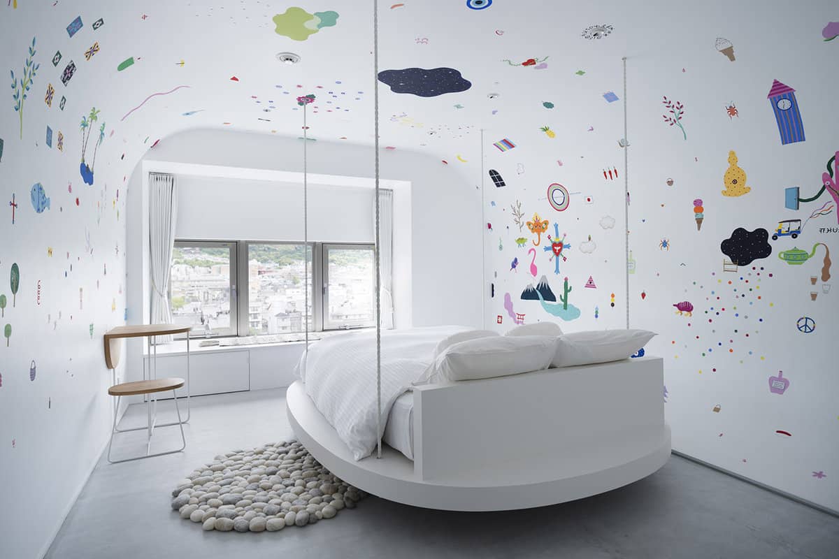 Bed under abstract painted walls
