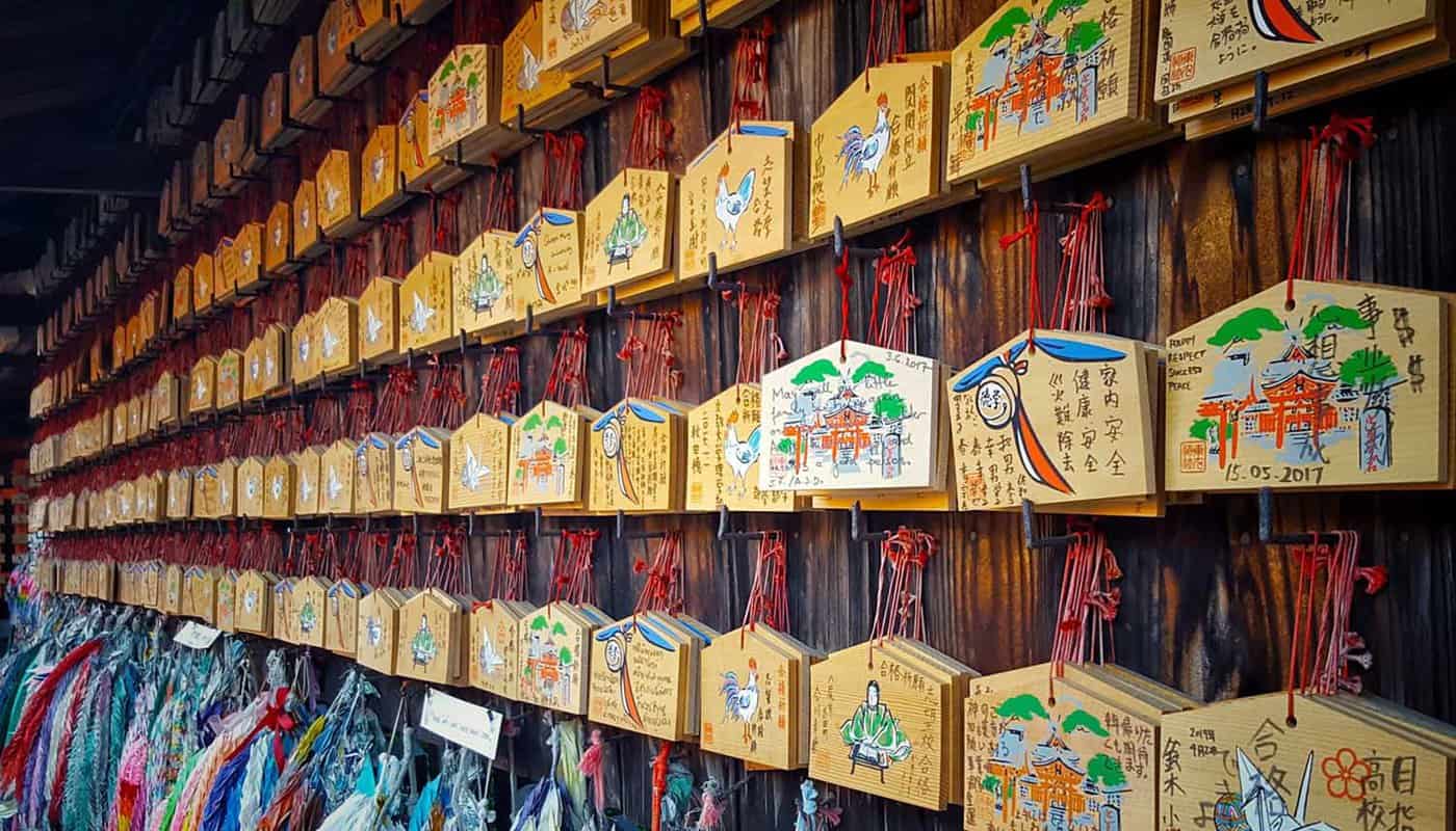 Wooded prayer tablets hanging up on a temple wall