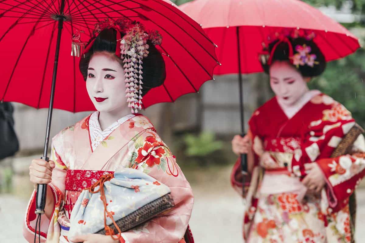 Geisha women with umbrellas