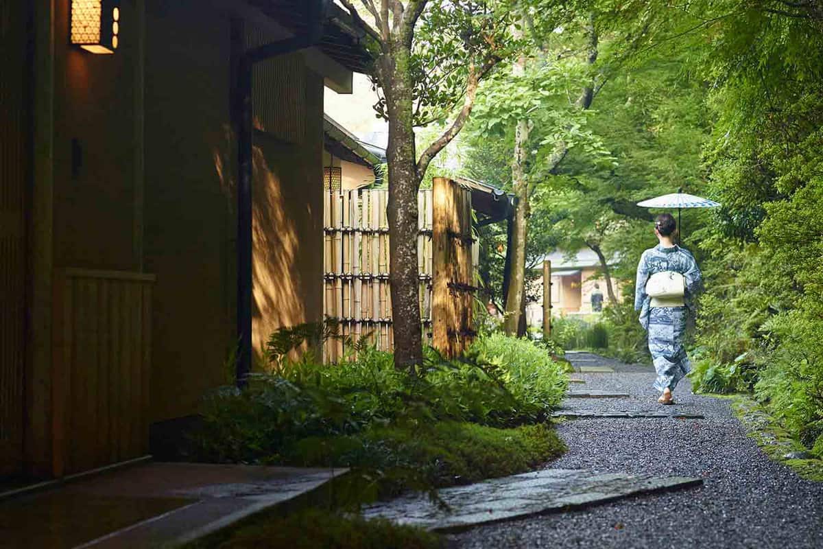 Woman walks down garden in traditional Japanese clothing