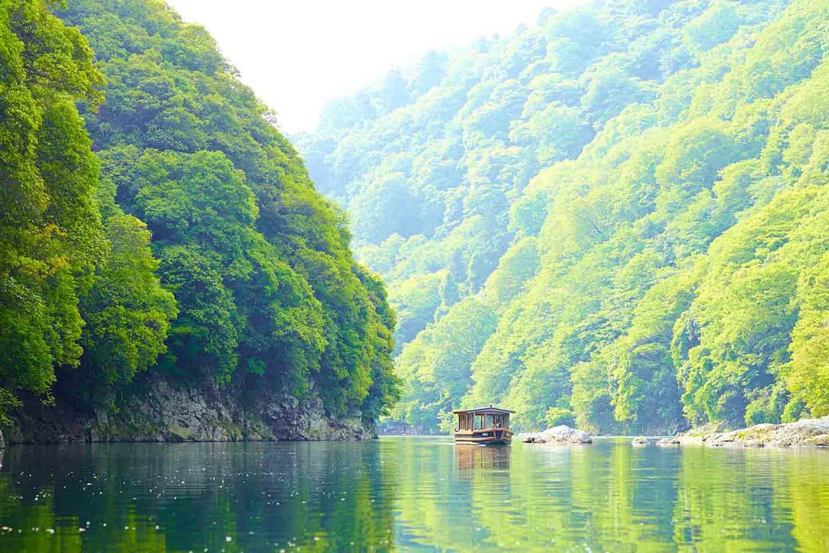 Boat on water in valley with greenery either side