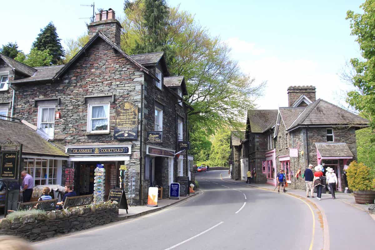 Pedestrians outside the gift shop and cafe in the Main Street in the centre of Grasmere Village