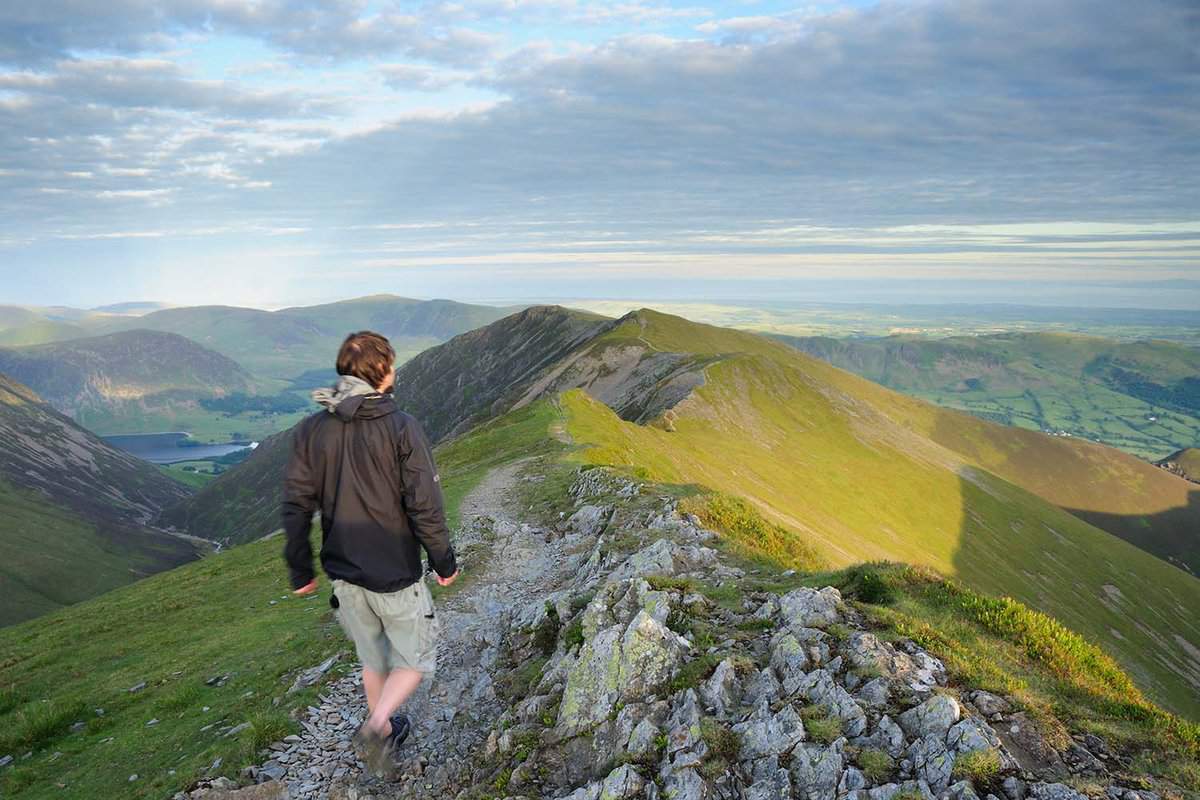 Walker on Whiteside above Gasgale Crags, mountain ridge in the English Lake District