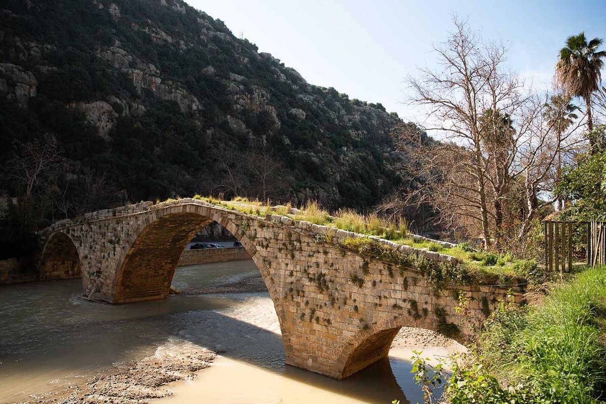 A medieval stone bridge built by Sultan Makluk archs over the Nahr al Kalb dog river near Beirut, Lebanon, Middle East.