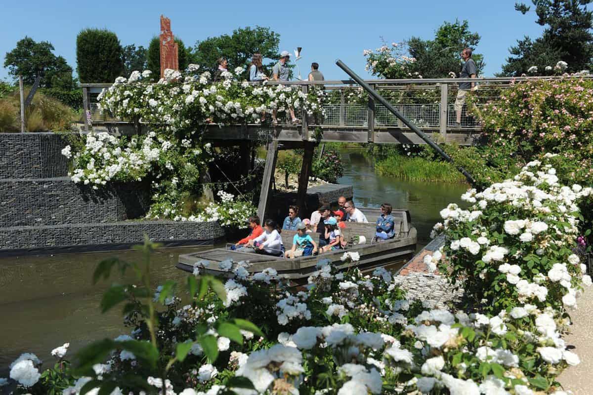 People boating on a small river through flowering gardens