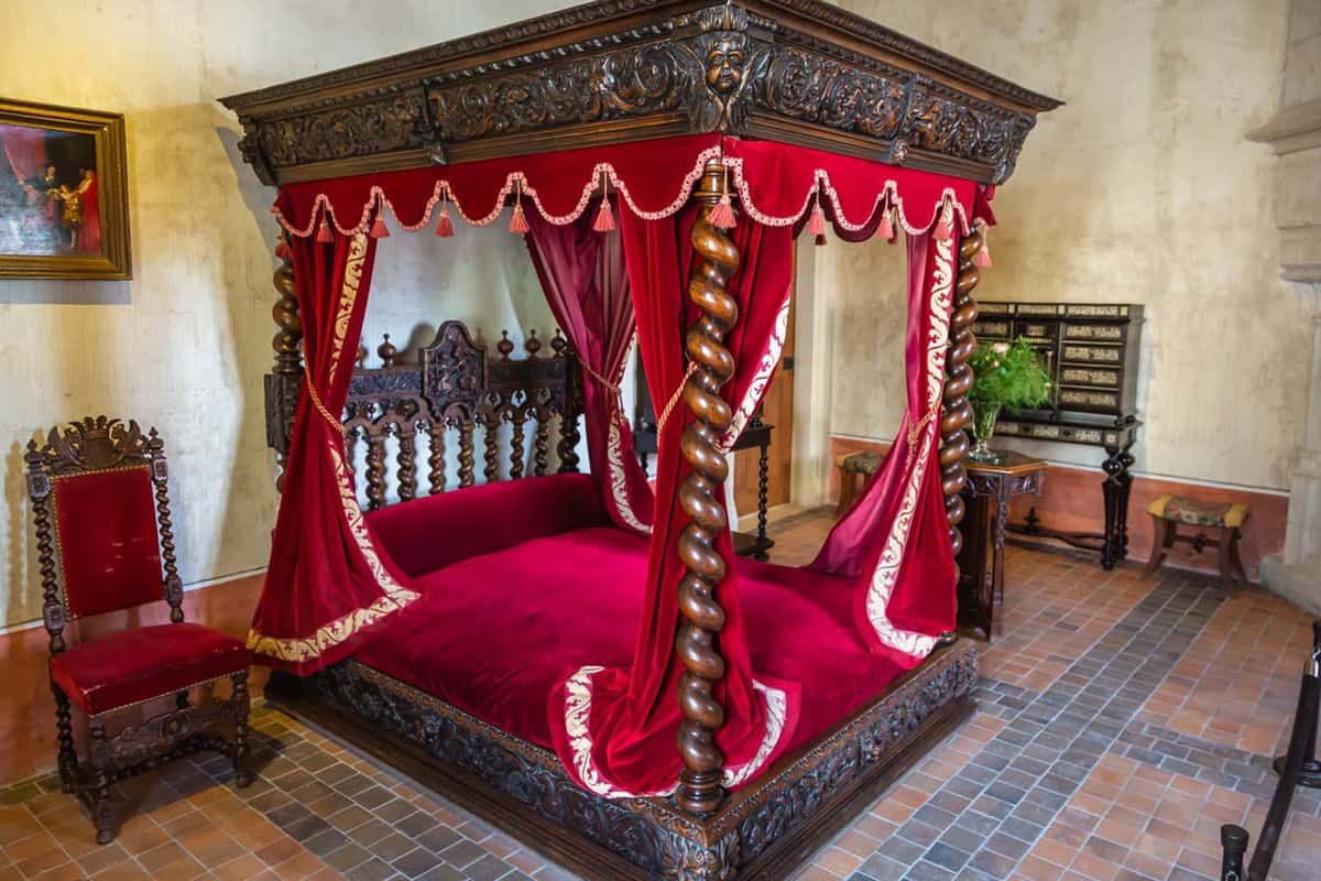 Da Vinci's preserved bedroom, with wooden four-poster bed and red drapes