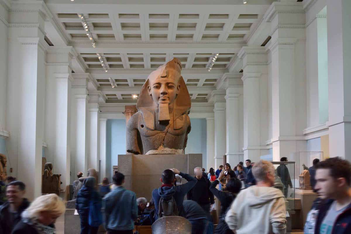 An Egyptian artefact surrounded by people viewing it