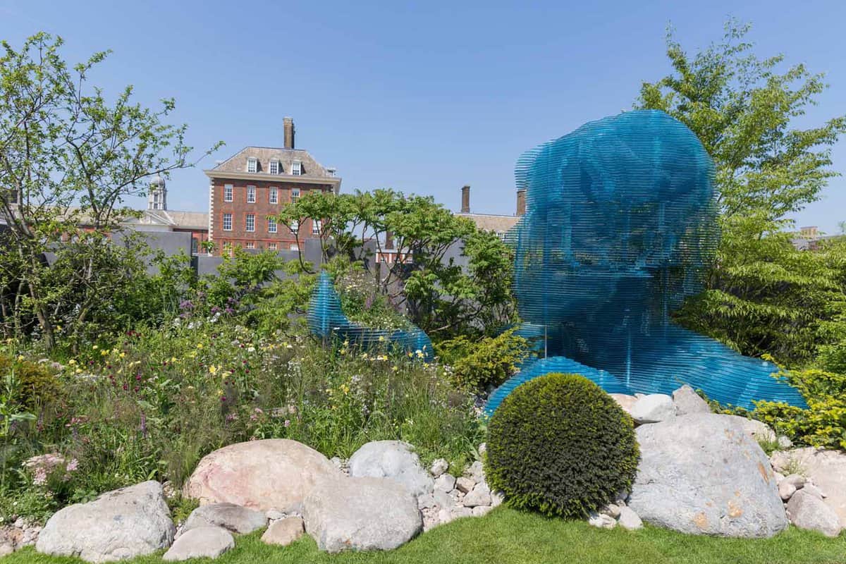 Blue slatted sculpture hidden amongst vegetation