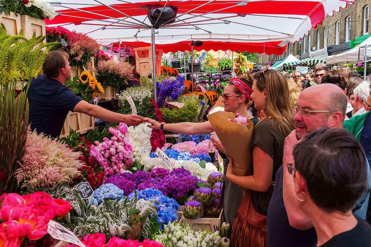People buying flowers at the market during the daytime