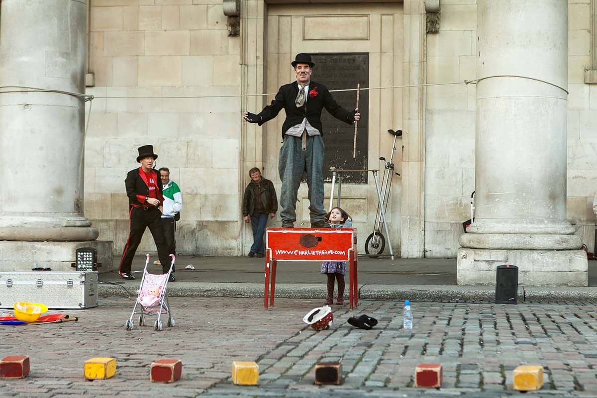 Street performer dressed up as Charlie Chaplin performing a show