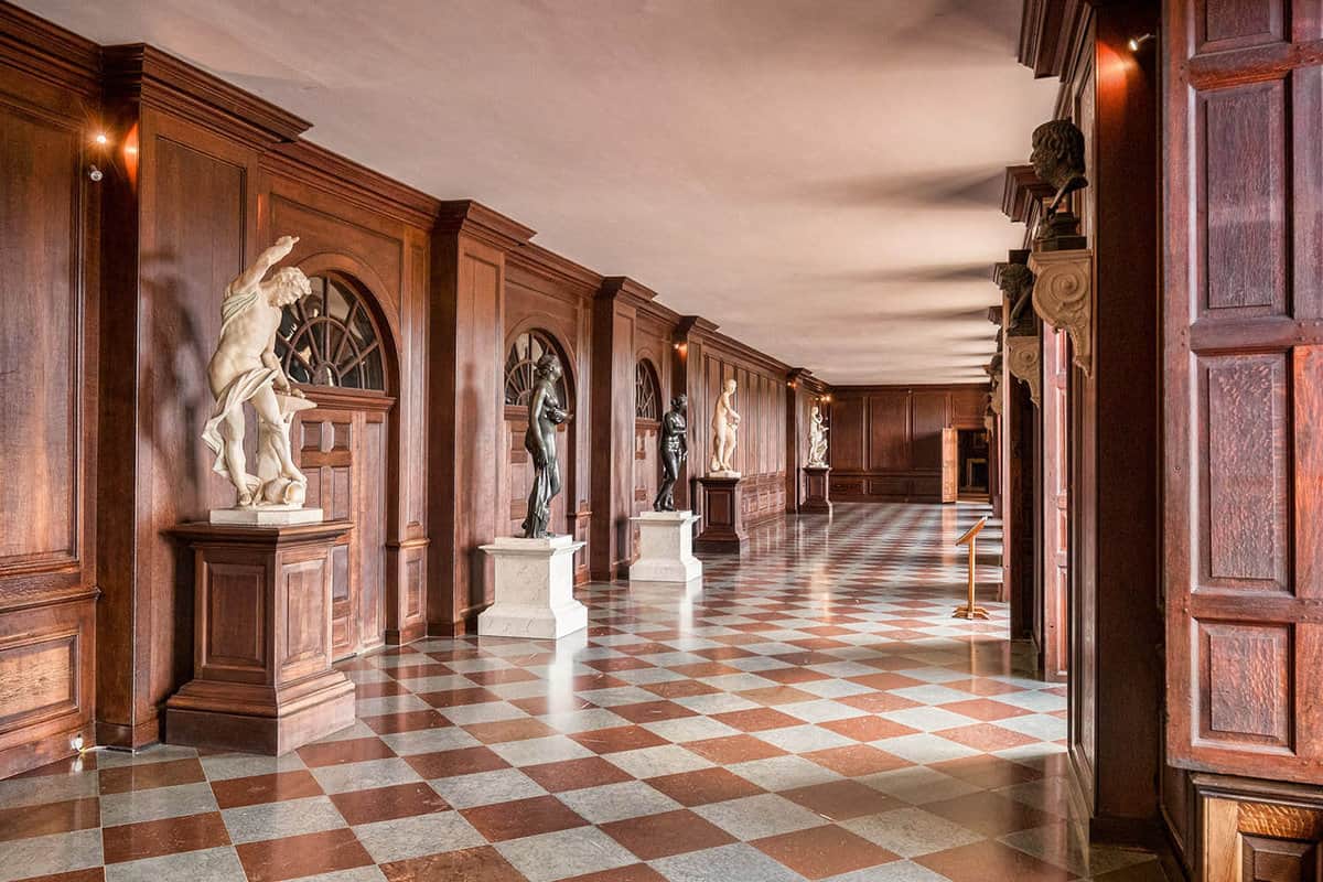 A hallway with sculptures lined up on the left side