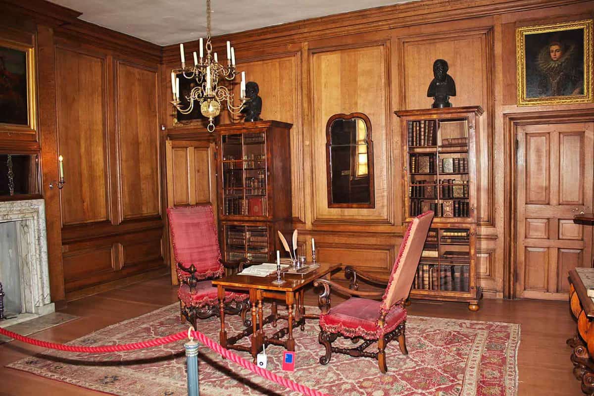 A room view with chairs, a table and some book shelves in the background