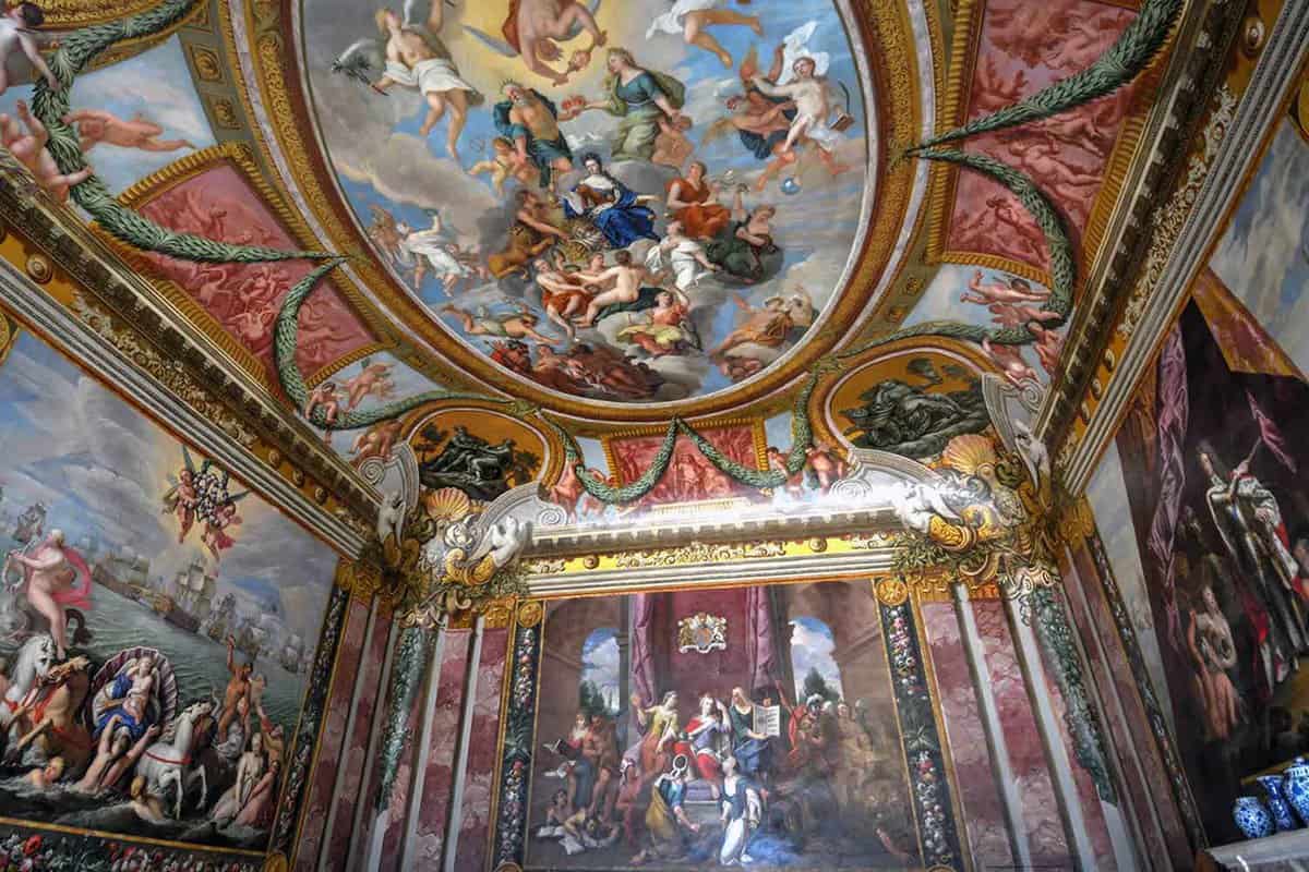 A room with paintings all over the walls and the ceiling