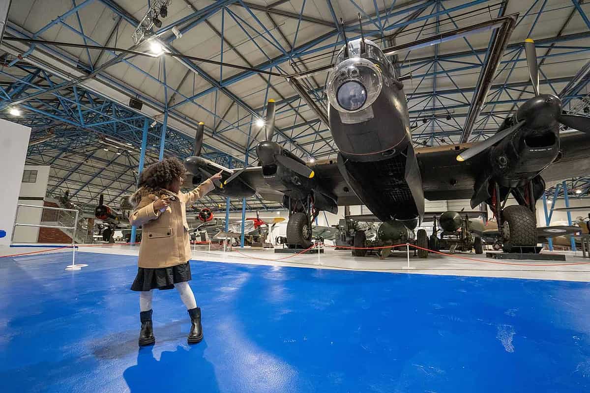 young boy pointing at a bomber plane in hangarat Royal Air Force Museum