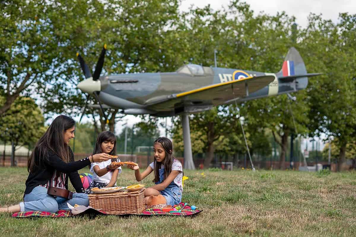 family picnicing infront of spitfire at Royal Air Force Museum