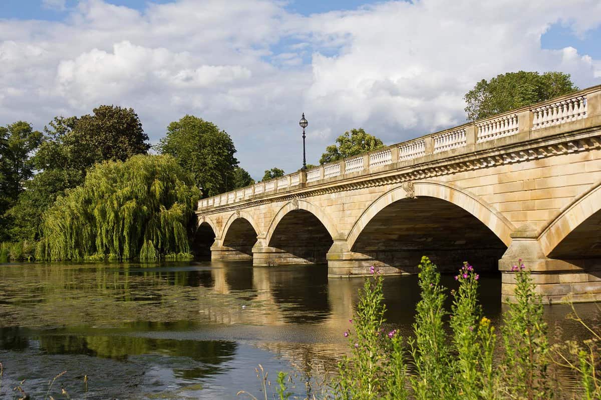 Lowered view of a river under a bridge during the summer time