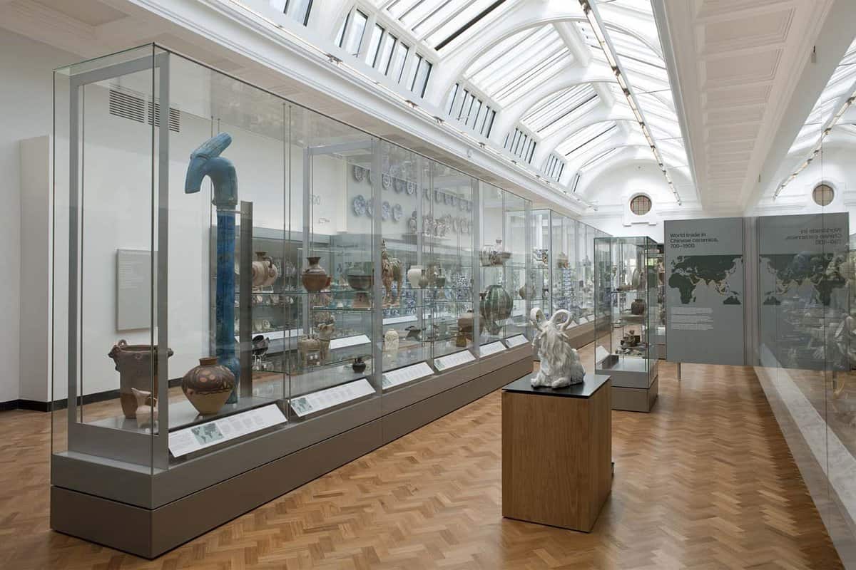 Interior gallery showing pottery exhibits in glass cases