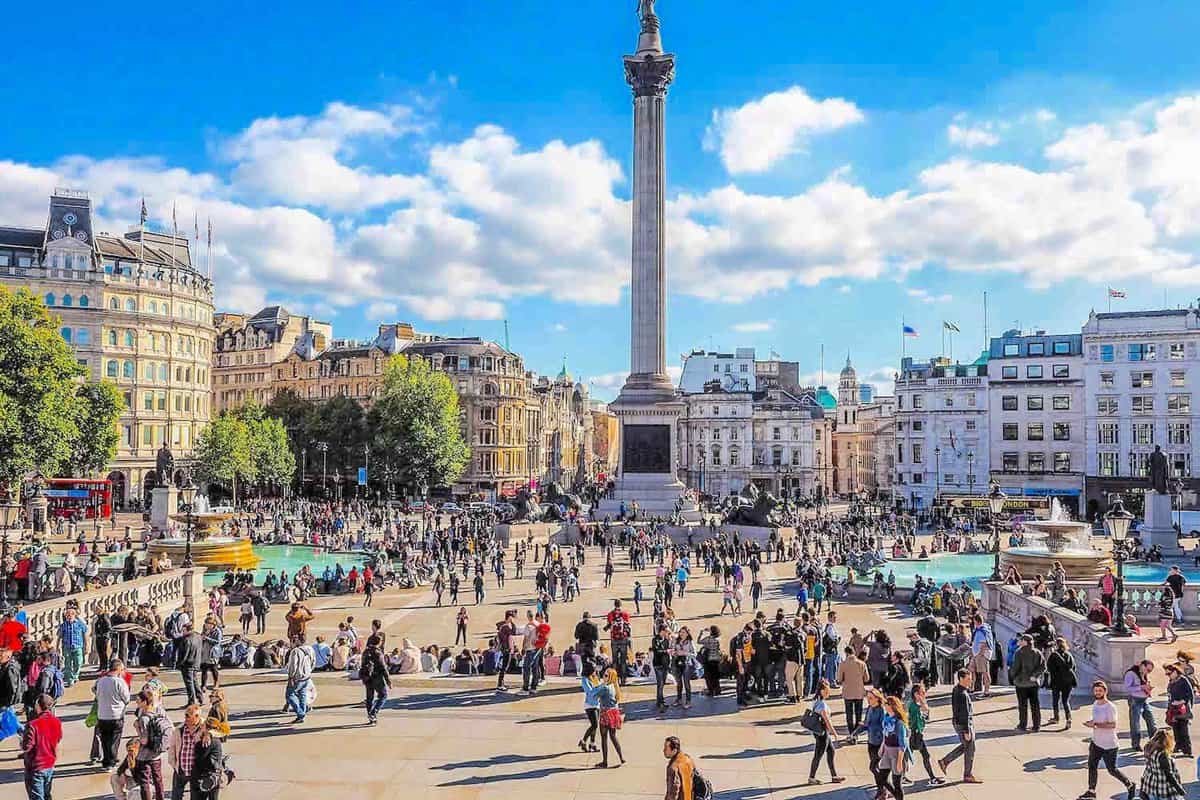 Trafalgar Square on a sunny day, filled with tourists