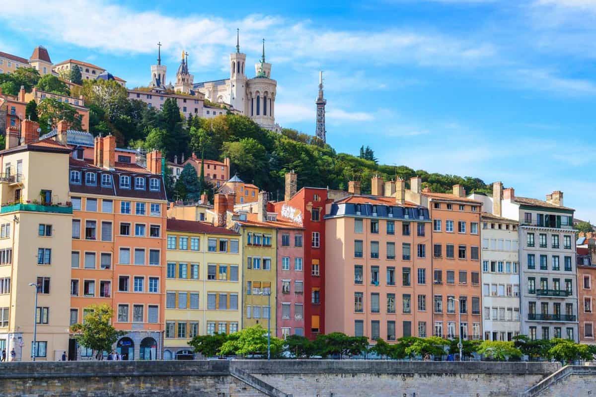 Lyon cityscape from Saone river with colorful houses, looking up at the hill