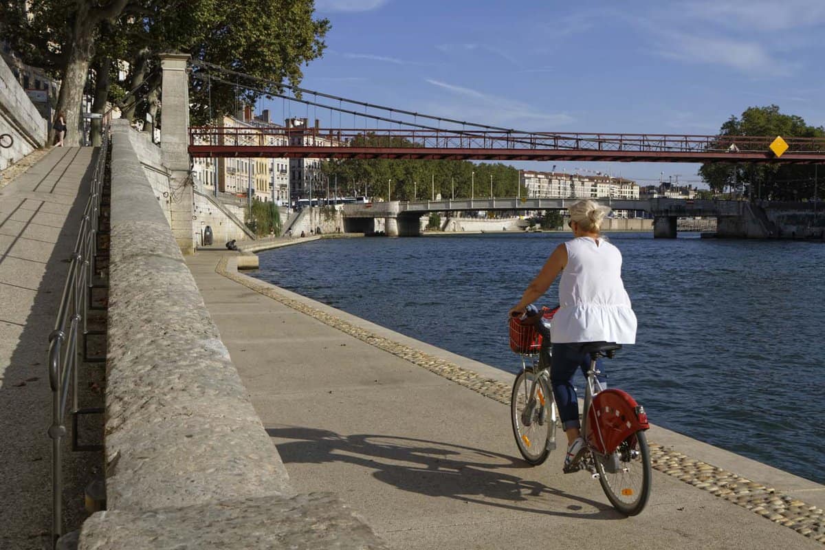 Woman on bike cycling along the river in Vieux Lyon