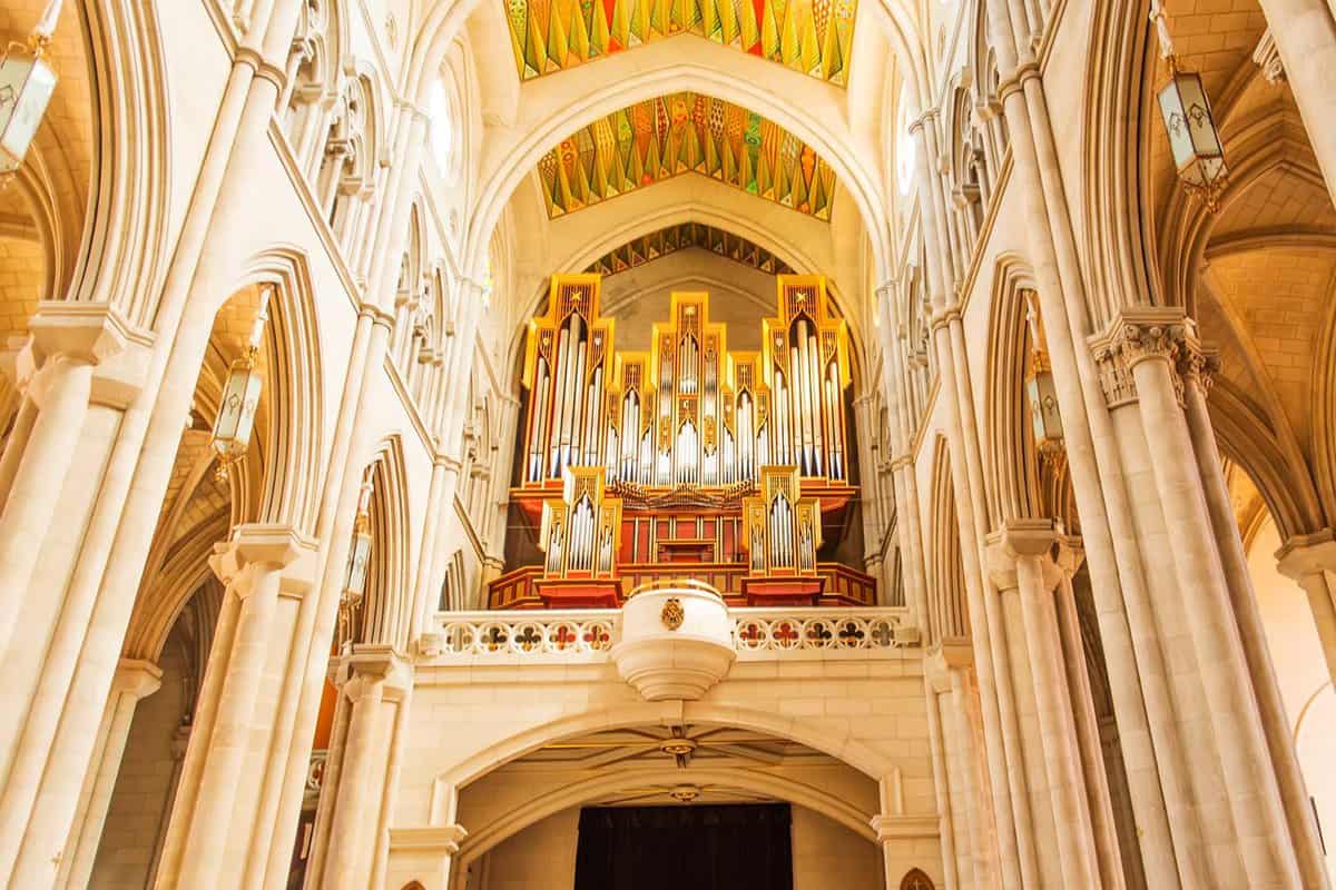 The organ in Almudena Cathedral. Parts of the organ are golden, and it is set into the building up high, visible for any visitors.