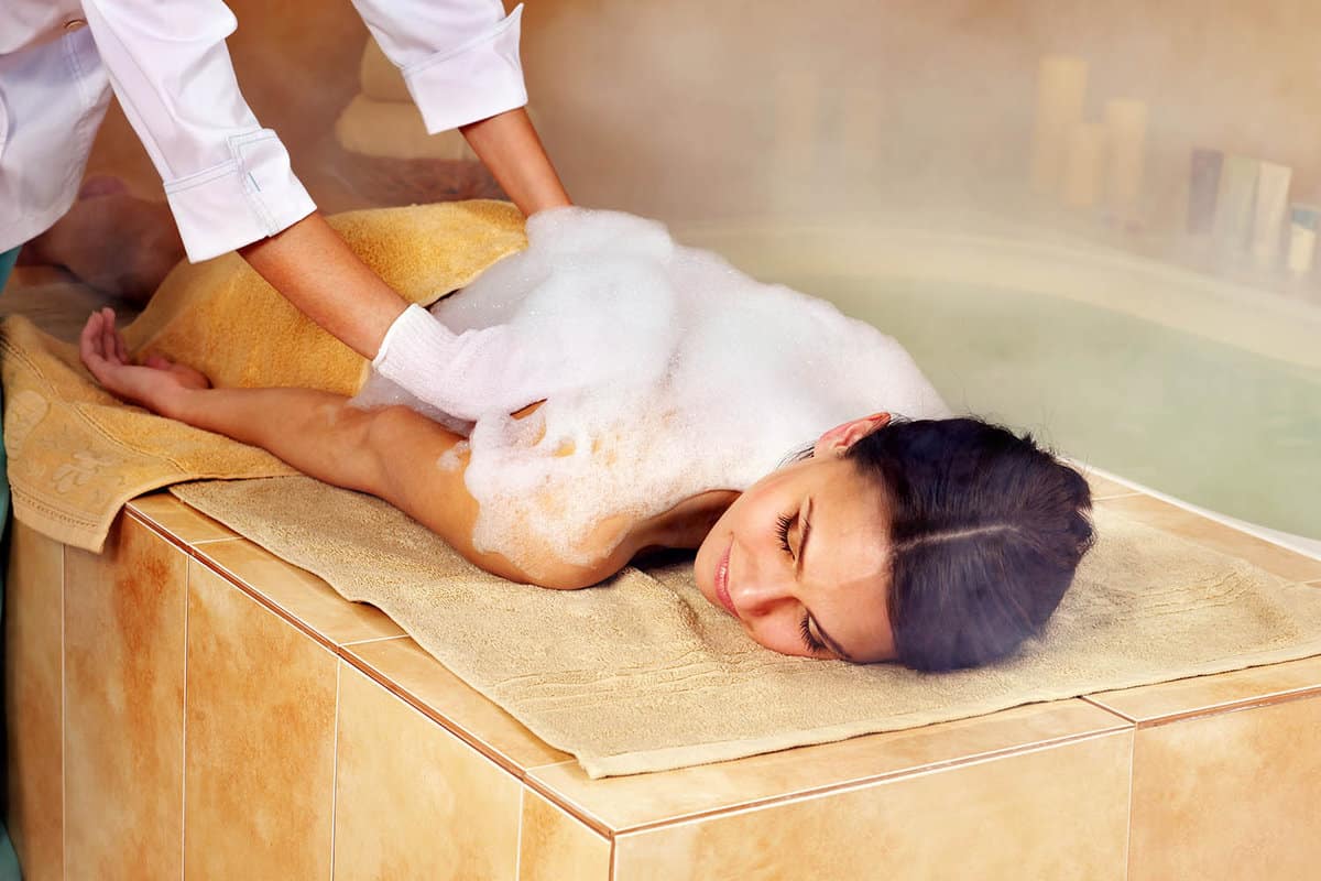 Woman receiving a foam massage in a hammam