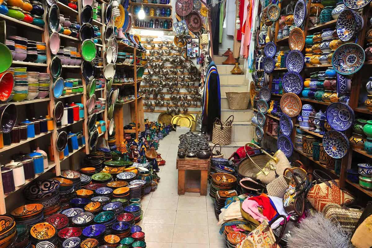 Interior of narrow shop selling brightly-coloured ceramic bowls