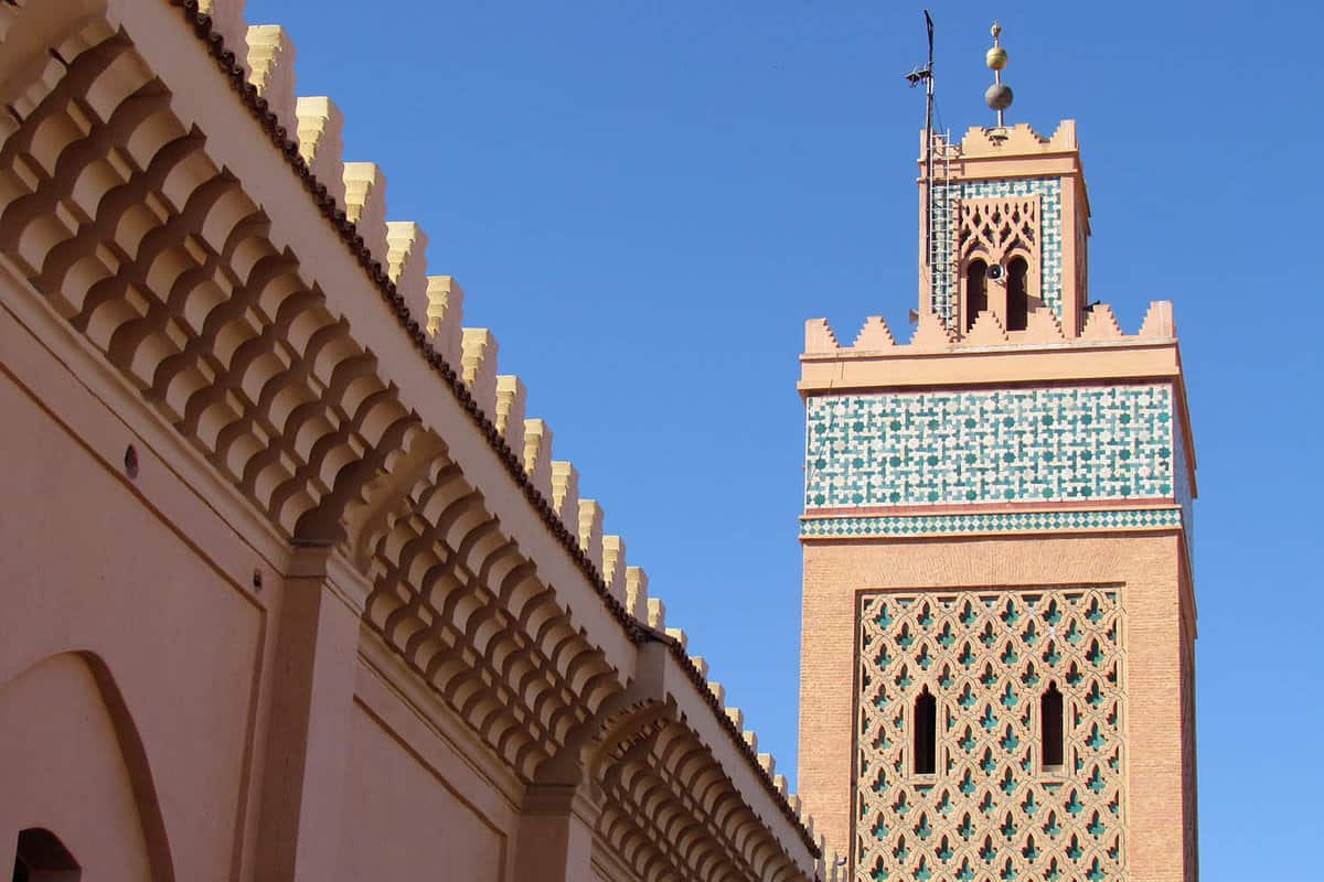 Blue-and-white-tiled mosque tower on a clear day