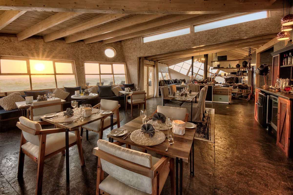 The dining area at Shipwreck Lodge with views out at sunset