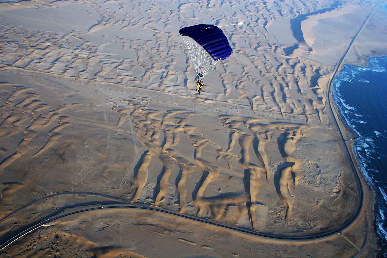 Lone parachute glides over the desert
