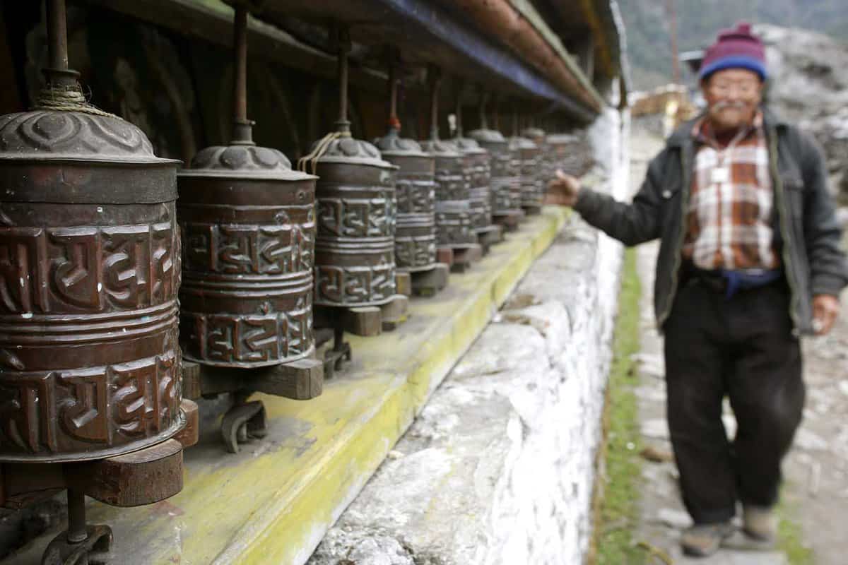 old man spinning praying wheel, annapurna, nepal