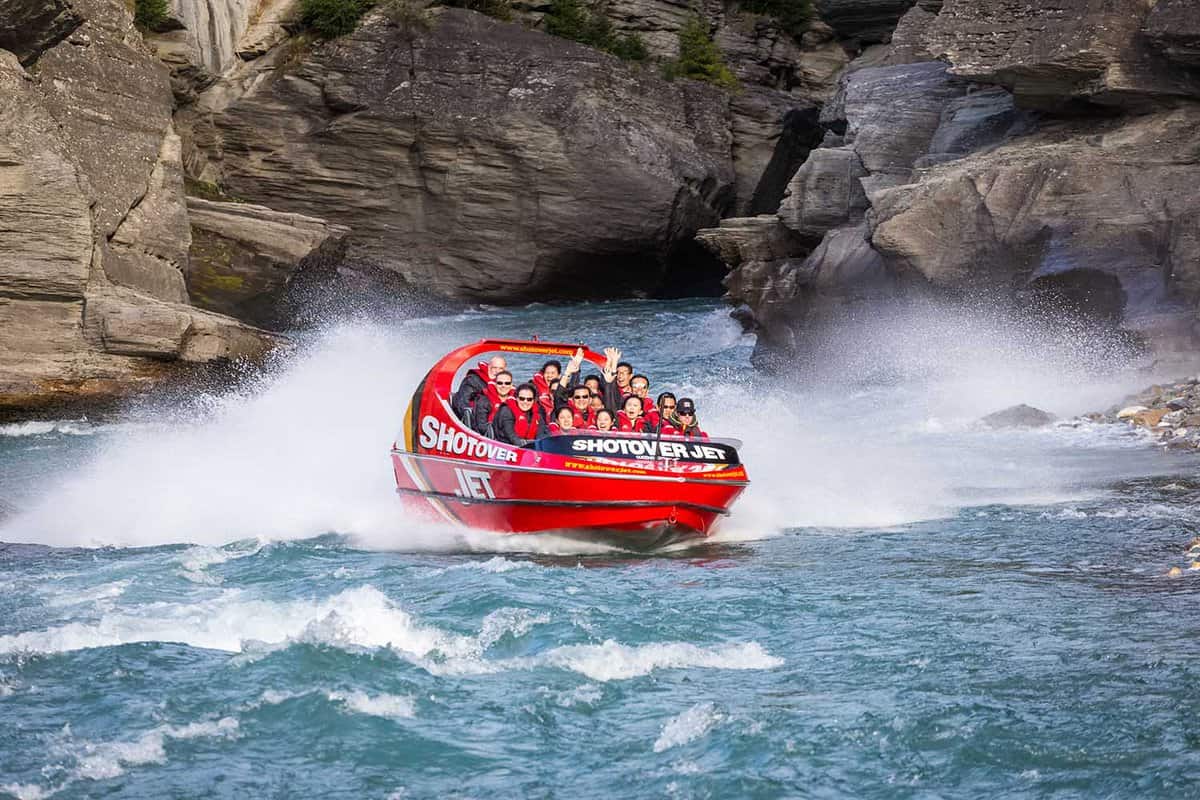 ourists enjoy a high speed jet boat ride on the Shotover River