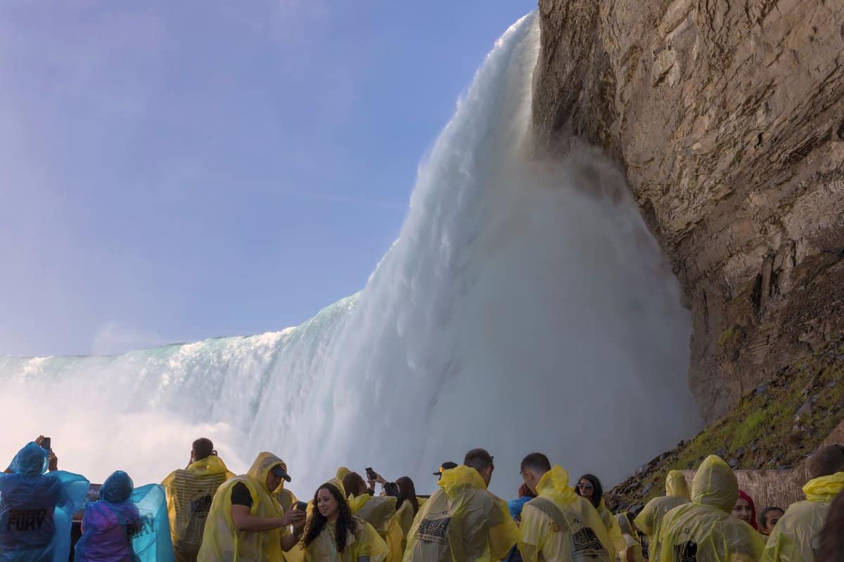 crowd of people in yellow rain macs on the viewing platform looking up at the falls