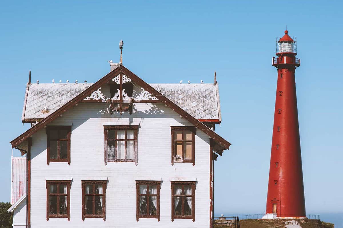 Lighthouse and white wooden old house in Norway traditional architecture norwegian culture Vesteralen islands