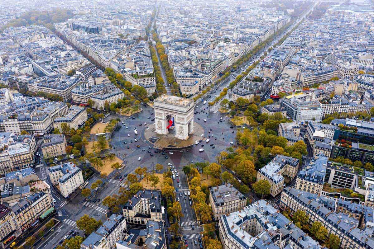 Aerial view of Arc de Triomphe surrounded by trees and the city of Paris