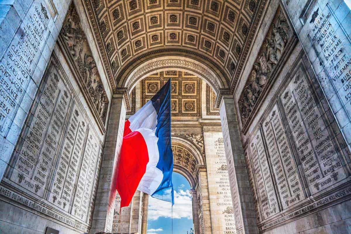 A French Flag hung under Arc de Triomphe