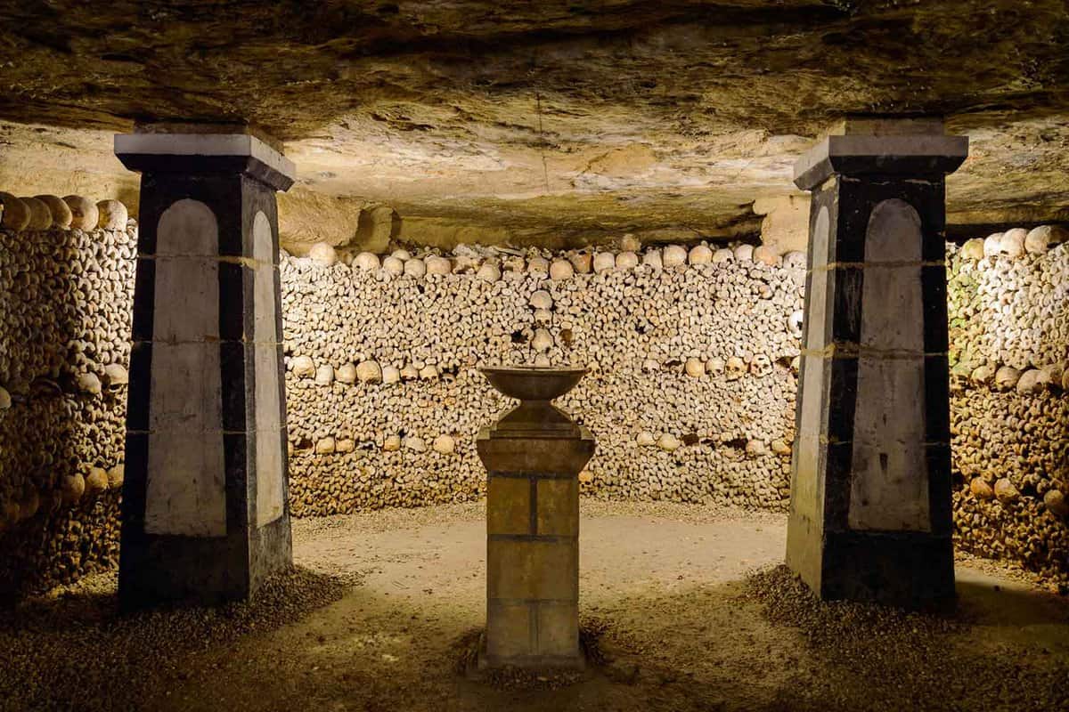 view of undeground cellar with two pillars and a wall of skulls