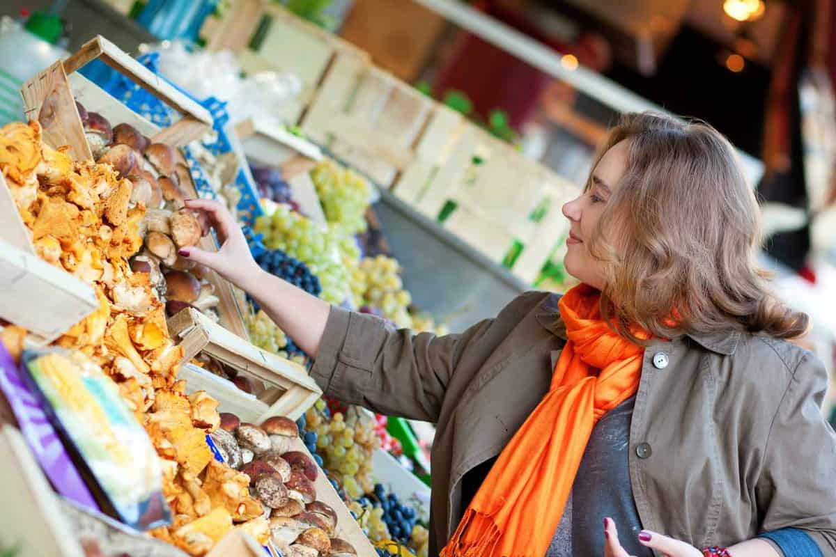 Woman buying mushrooms at market