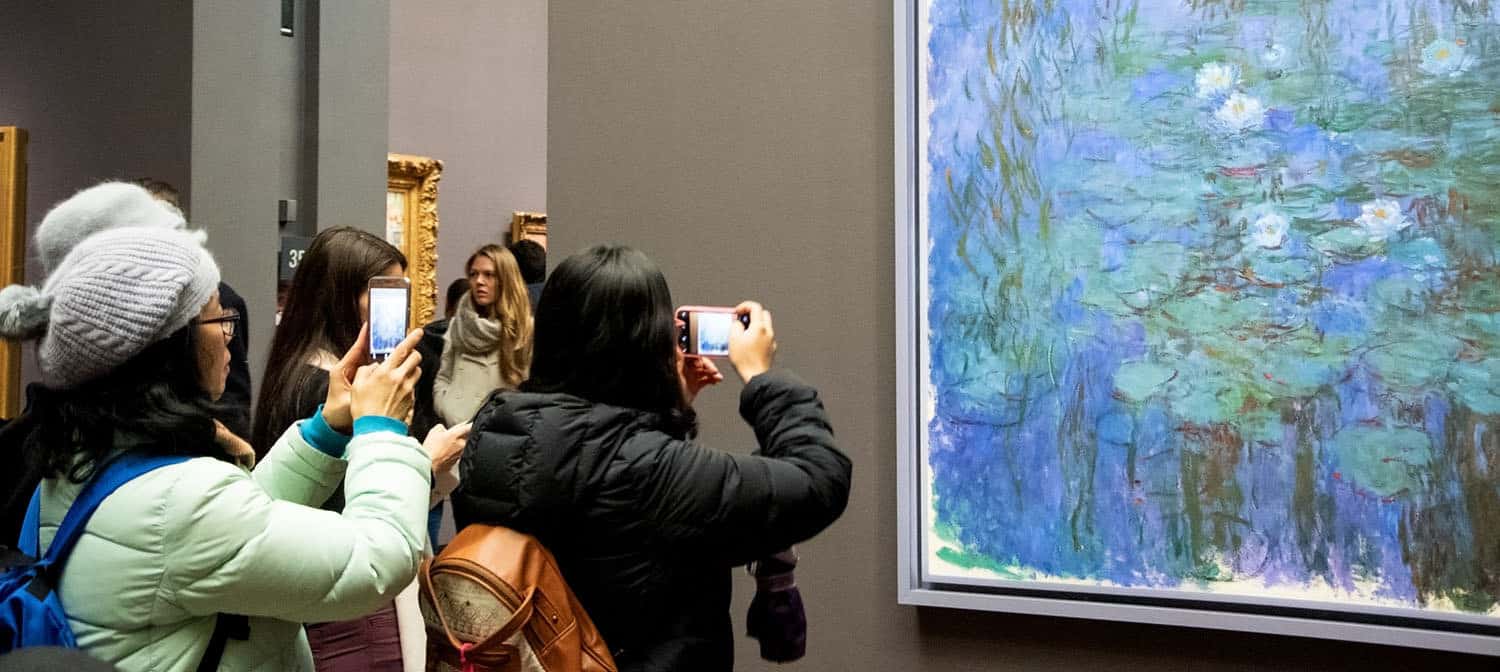 Tourists taking photographs of the painting in front of them