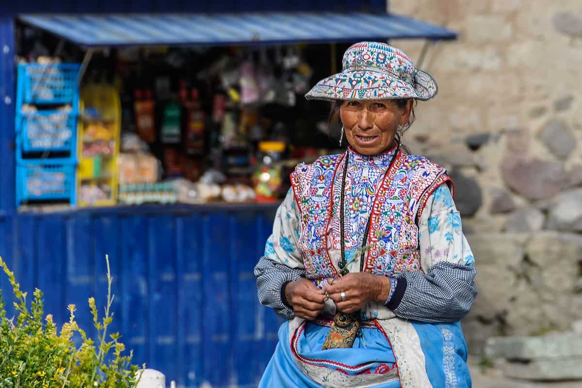 A woman stands in front of a blue painted stall