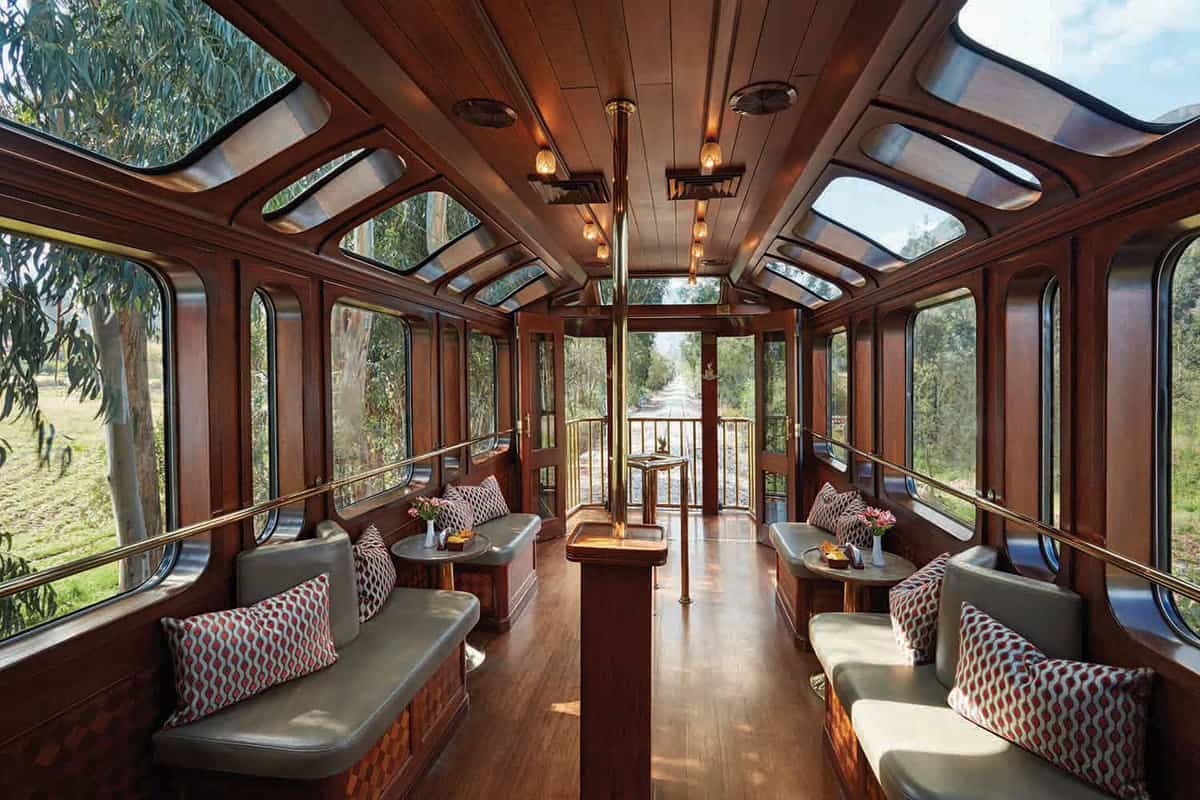 A train carriage with comfortable seating, and large windows and skylights
